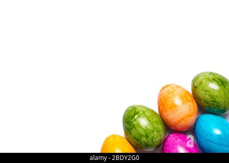 Easter eggs in different colors in bottom right corner isolated on white background Stock Photo