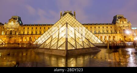 Night View of famous Louvre Museum with Louvre Pyramid, Paris. Stock Photo