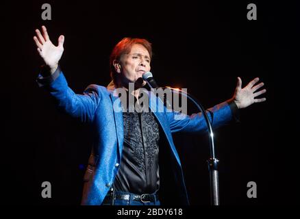 Cliff Richard performs at the Royal Albert Hall. He is the third top selling artist in the UK behind the Beatles and Elvis Presley. Stock Photo