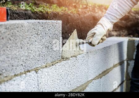 wall construction from expanded clay blocks, applying mortar with trowel Stock Photo