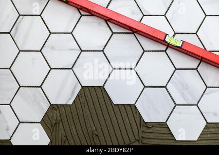 tiling - laying marble texture hexagon tiles on the floor Stock Photo