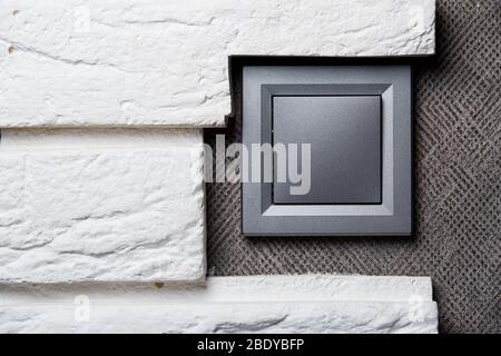 Two-key switch of gray color near the door, plastic mechanical switch. The light switch is installed after repair. Energy saving concept. Close up lig Stock Photo