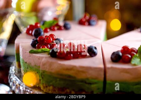 Layered creamy fruit cake with berries, close up view. Cheesecake with blueberries on plate. Stock Photo