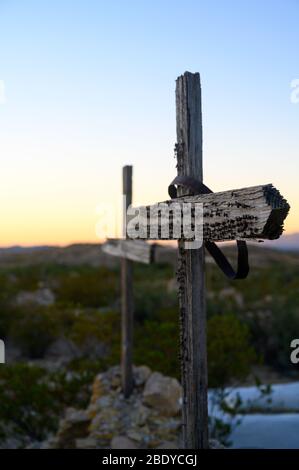 Two wooden crosses with nails in them mark graves in the Terlingua Cemetery in West Texas, where the graves are marked by handmade embellishments. Stock Photo