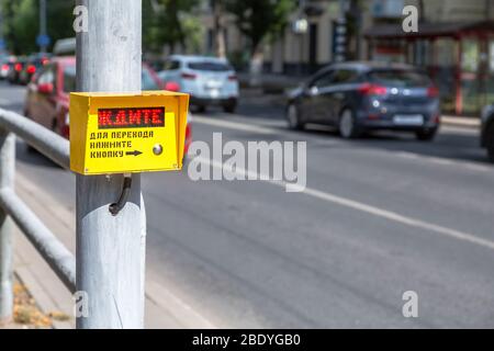 Pedestrian wait signal, used to help people cross the road safely. Text in Russian: WAIT. To cross street - push button Stock Photo