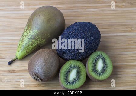 Close up view of kiwi, pear and avocado on wood background. Fruits and vegetables concept. Stock Photo