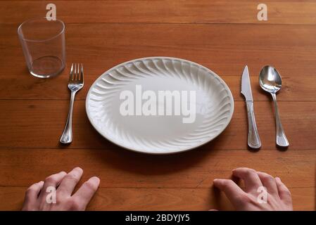 Point of view of a person about to eat on an empty porcelain plate Stock Photo