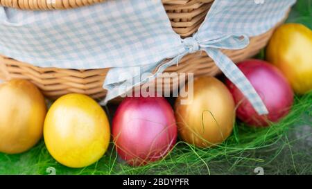 Colorful bright self painted Easter eggs near the nice rustic basket. Stock Photo