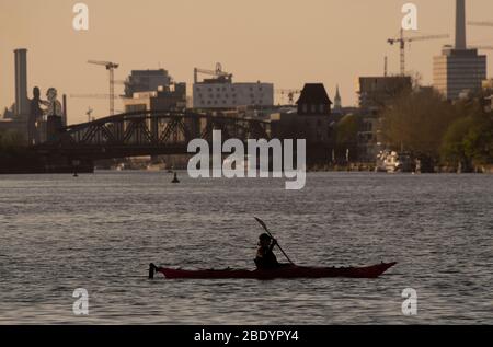 Berlin, Germany. 10th Apr, 2020. A woman paddles across the Spree at Treptower Park. Credit: Paul Zinken/dpa/Alamy Live News Stock Photo