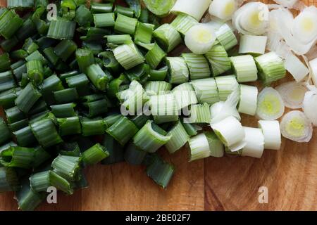 Chopped spring onion on wooden cutting board Stock Photo