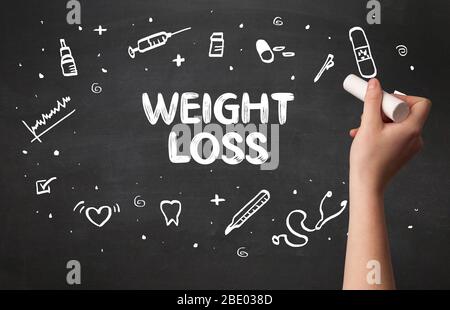 Hand drawing  WEIGHT LOSS inscription with white chalk on blackboard, medical concept Stock Photo