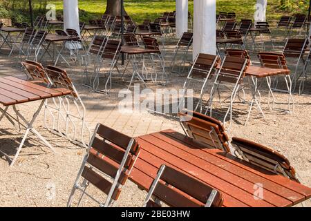 empty chairs and tables folded up in a beer garden Stock Photo