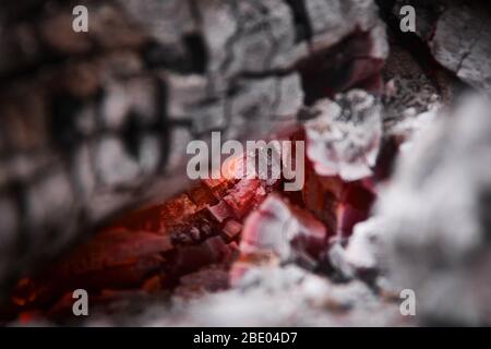 Glowing embers at the heart of a wood fire. Campfire, outdoors, rustic setting. Stock Photo