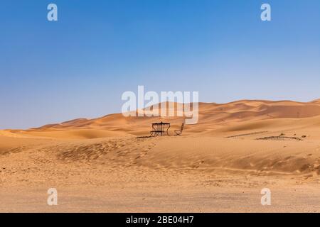 Table and Chair in the distance on a Sand Dune in the Sahara Desert Stock Photo