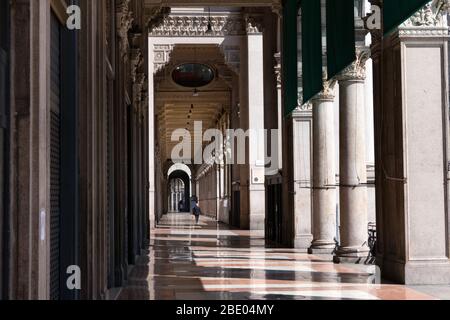 Deserted Piazza Duomo in Milan, Italy during COVID-19 pandemic with lone man walking. Daily life in Milano. Italian city and coronavirus outbreak Stock Photo