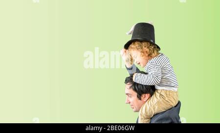 Conceptual photo of a man playing with his toddler son with rabbit ears at Easter Holidays at home during lockdown in Spain, Europe. Stock Photo