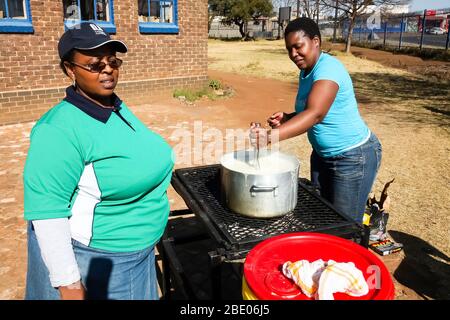 Soweto, South Africa - July 21, 2012: African Woman cooking Mielie Pap maize porridge on side street in urban Soweto Stock Photo