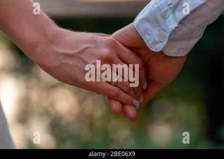 Close up of Bride and Groom Holding Hands With Wedding Rings On It. Giving of Wedding Rings And Vows Outdoors . Wedding In Park. Stock Photo