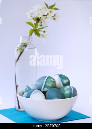 Blue, green, turquoise and white homemade easter eggs colored with a red cabbage natural colour on a white background with blank space decorated. Stock Photo