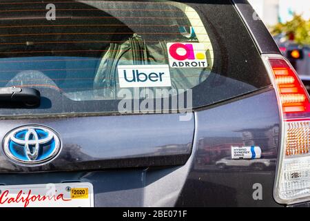 Jan 18, 2020 San Francisco / CA / USA - UBER and Adroit stickers on the rear window of a Toyota Prius Hybrid vehicle offering rides in San Francisco Stock Photo