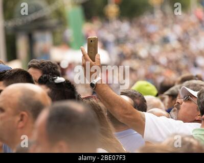 Mobile telephone being held high taking photos in a large packed crowd Stock Photo