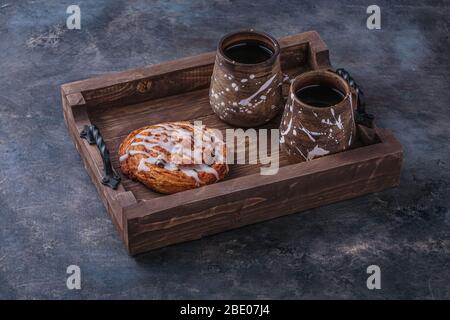 Sweet pastry with cup of coffee on wooden board. Stock Photo