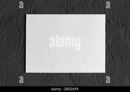 white textured paper card on dark concrete background Stock Photo
