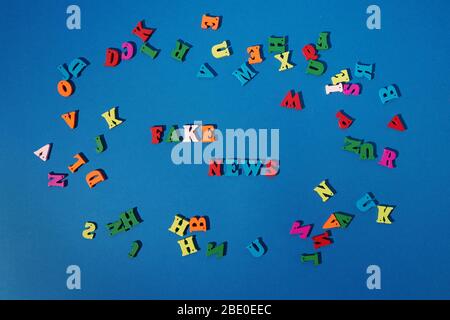 Fake news concept. Word made of wooden letters on a blue background Stock Photo