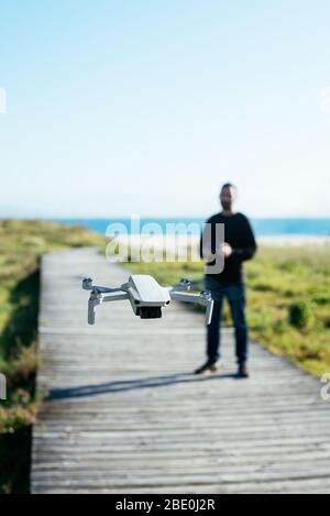 Young man flying a dron near to the beach Stock Photo