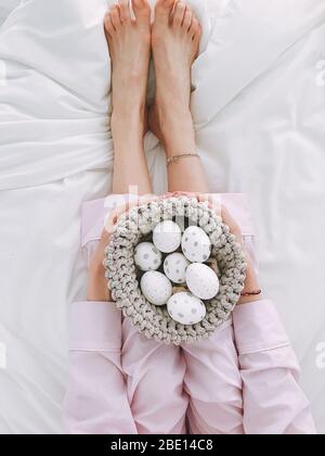 A woman holding gray eggs in her basket. Stock Photo