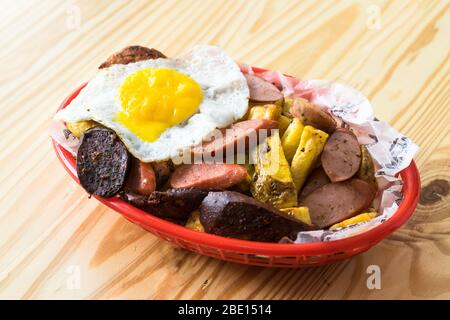Peruvian salchipapa: hot dog with fried egg and potatoes Stock Photo