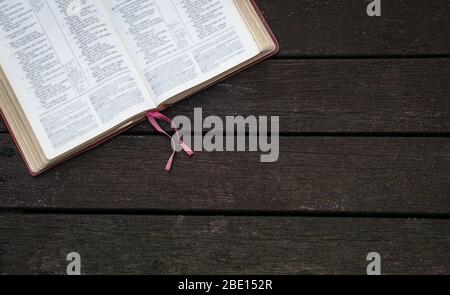 Top view of open Holy Bible  on the corner of dark wood background Stock Photo