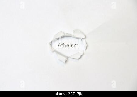 Word atheism on white isolated background, the inscription through the wound hole in the paper. Stock photo for web and print with empty space for text and design. Stock Photo