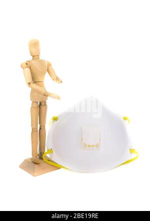 Small wooden mannequin next to a N95 face mask, isolated on a white background Stock Photo