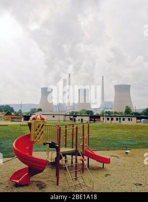 2007 - Coal powered company cooling tower behind a school playground Stock Photo