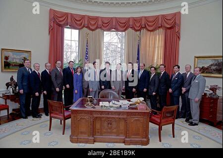 3-24-1988 President Reagan during a photo opportunity with senior staff members of the National Security Council NSC staff  John Negroponte, Colin Powell, Paul Stevens, William Cockell, Herman Cohen, Stephen Danzansky, Robert Dean, Fritz Ermarth, Alison Fortier, D Barry Kelly, James Kelly, Robert Linhard, Robert Oakley, Peter Rodman, Nicholas Rostow and Jose Sorzano in the Oval Office Stock Photo