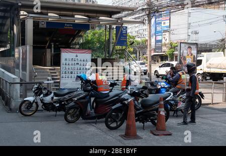 Motorcycle taxis wait for few customers after the Bangkok government ordered Most businesses closed due to the rapid spread if the Covid-19 virus or coronavirus in Thailand. Stock Photo