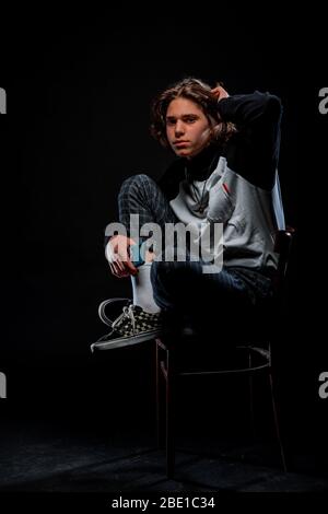 Portrait of a trendy guy wearing turtleneck jumper, checkered pants and stylish sneakers Stock Photo
