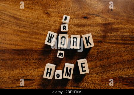 'Work from home' text made of wooden cube on  wooden background. Stock Photo