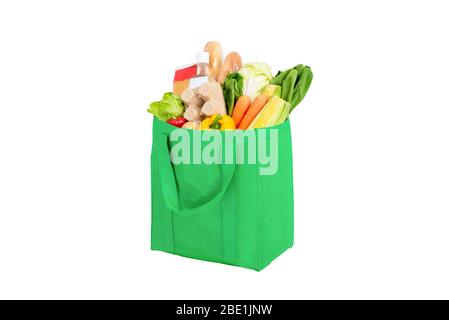 Green reusable shopping bag full of vegetables and groceries isolated on white background Stock Photo