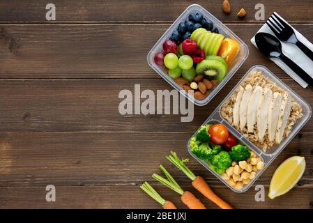 Top view of wholesome nutrient rich food set in take away boxes on wood table background with copy space Stock Photo