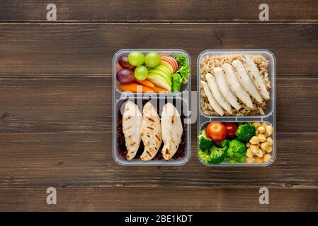 Nutrient rich healthy low fat food in takeaway meal box sets on wood background top view with copy space Stock Photo