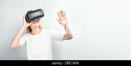 happy smiling young beautiful girl l getting experience using VR-headset glasses of virtual reality at home much gesticulating hands Stock Photo