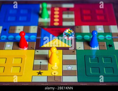 Pieces and a die on a Ludo board game Stock Photo