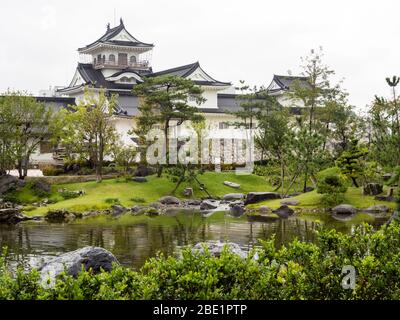 Traditional Japanese garden with pond and white castle in Toyama, Japan Stock Photo