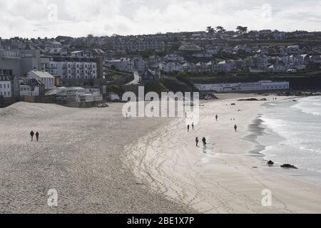 Carona virus precautions Social distancing people walking on beach keeping well apart Landscape format Stock Photo