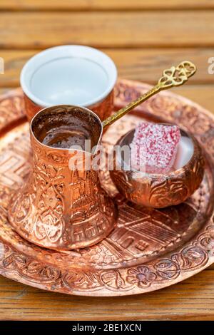 Traditional black bosnian coffee in beautiful copper cezve at wooden table Stock Photo
