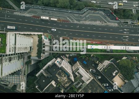 Aerial drone overhead view of Chongqing light rail carriage on rail to Liziba transit along residential buildings on the street Stock Photo