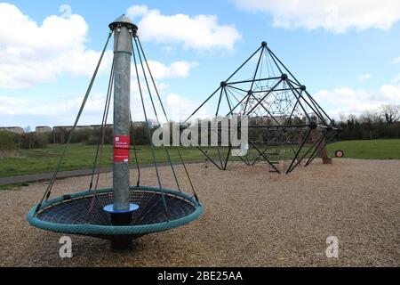 Ciity council coronavirus notice on a public park kids playground spinner Stock Photo