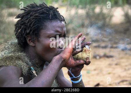Hadza man smoking from a traditional clay pipe Photographed near Lake Eyasi, Tanzania, Africa Stock Photo